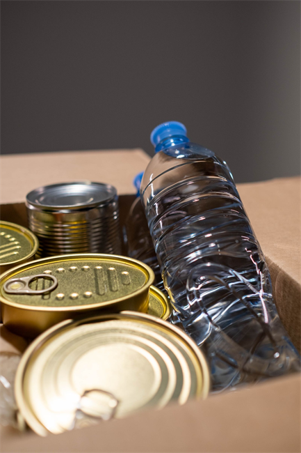 Tinned food and bottled water packed in a box